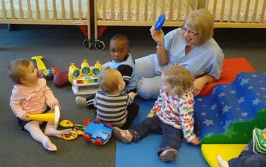 a person and several children sitting on a blanket