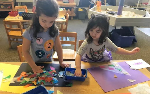a couple of young girls playing with toys on a table