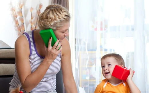 a person and a child looking at a cell phone