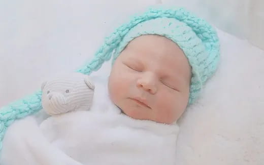 a baby sleeping in a blanket