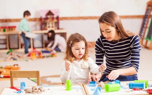 a person and a child playing with toys on the floor