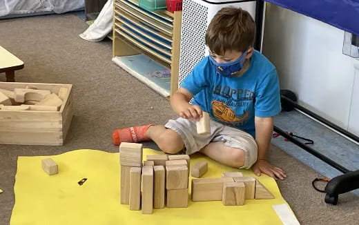 a boy sitting on a yellow block