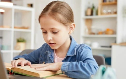 a young girl reading a book