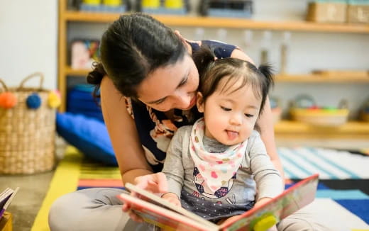 a person reading a book to a baby