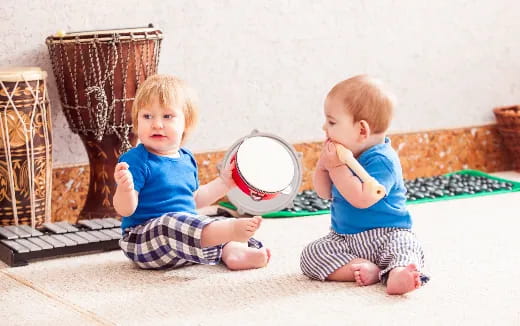 two babies sitting on the floor