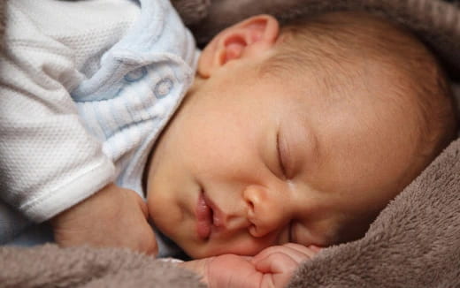 a baby sleeping on a blanket