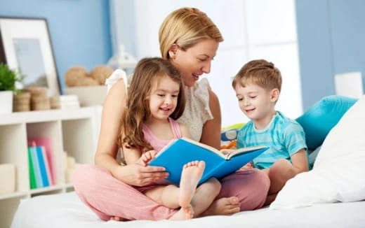a person reading a book to a couple of children