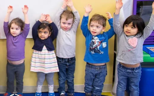 a group of children raising their hands