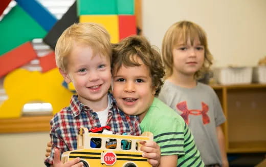 a group of children holding a toy car