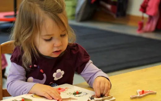 a young girl sitting at a table