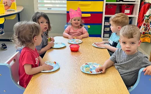 a group of children eating at a table