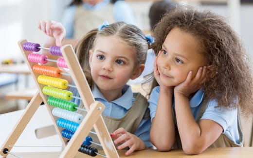 a couple of children looking at a toy
