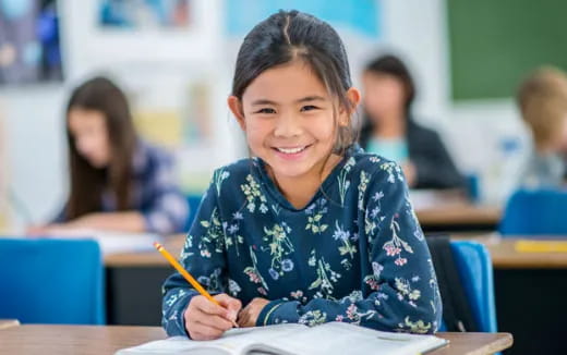 a young girl sitting at a desk