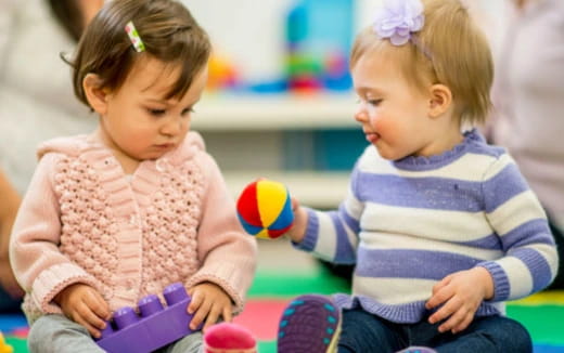 a couple of young girls playing with toys