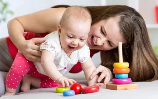 a person and a baby playing with toys