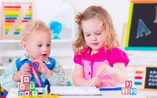 a couple of children sitting at a table with toys