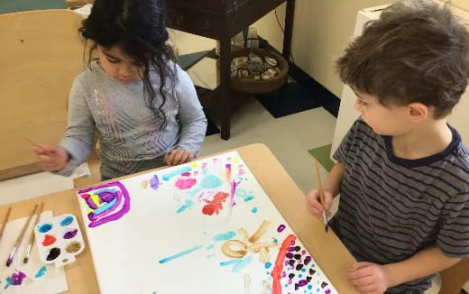 a few children playing with colorful paper