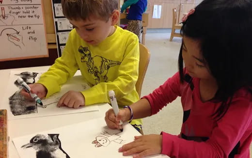a young boy and girl drawing
