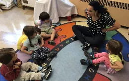 a person and several children sitting on the floor