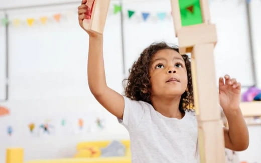 a young girl raising her hands
