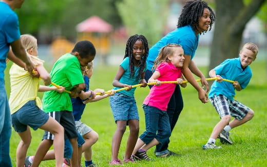 a group of children playing with a rope