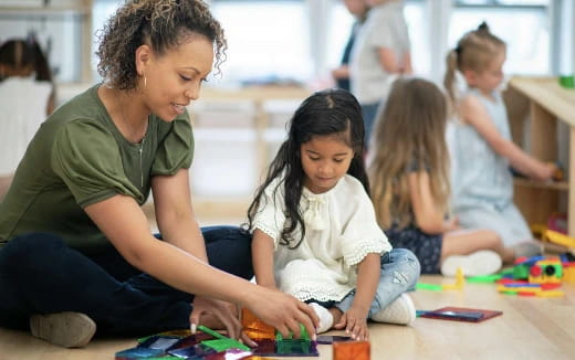 a person and a couple of children playing with toys