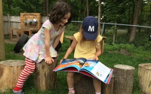 a person reading a book to a young girl