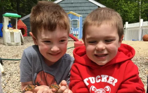 two boys sitting on the ground