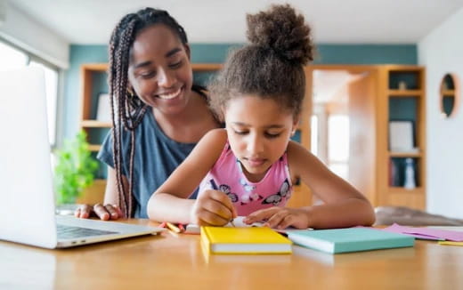 a person and a child looking at a laptop