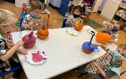a group of children sitting around a table with food