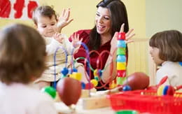 a person and children sitting at a table with balloons