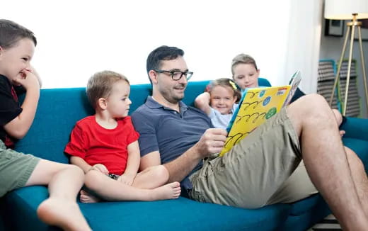 a man and a group of kids sitting on a couch