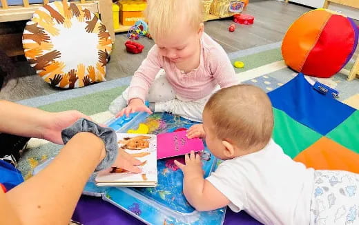 a baby and a person sitting on the floor