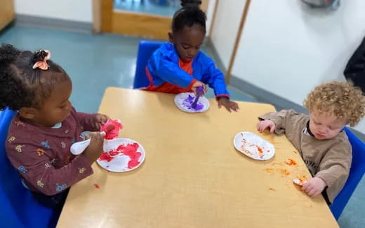 a group of children sitting at a table eating food