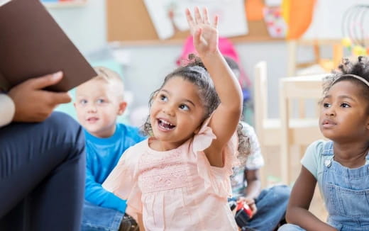 a group of children raising their hands