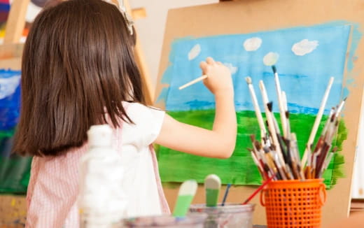 a girl painting on a white board