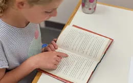 a child writing on a piece of paper