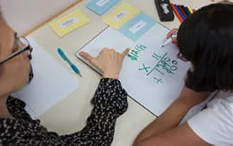 a man and a woman drawing on a white board