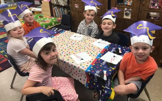 a group of children sitting around a table