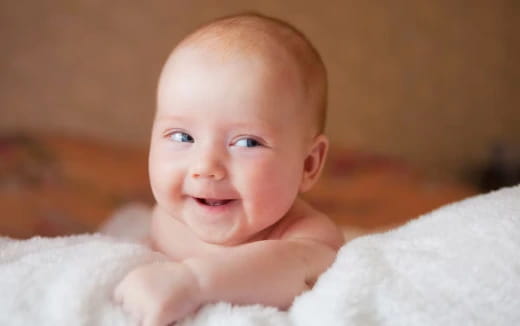 a baby lying on a blanket