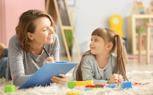 a couple of young girls playing with a toy