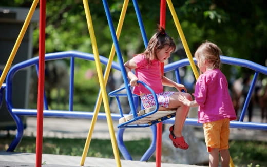 a couple of children playing on a playground