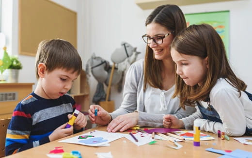 a person and two children playing a board game