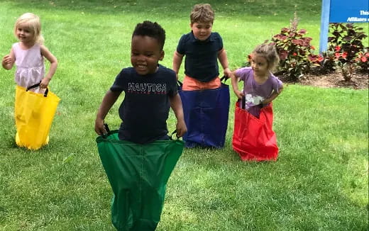 a group of children walking in a grassy area