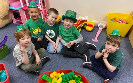 a group of kids sitting on the floor with toys