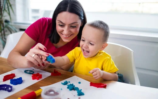 a person and a child playing with toys on a table