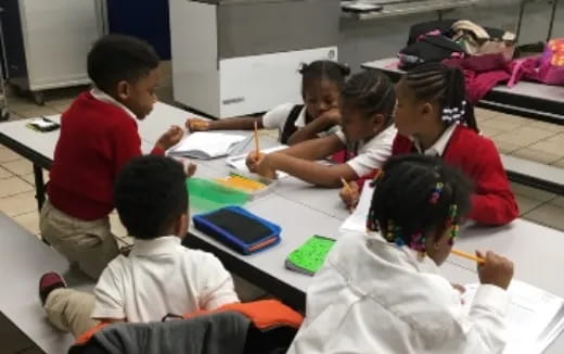 a group of children sitting around a table