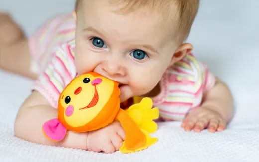 a baby with a yellow toy