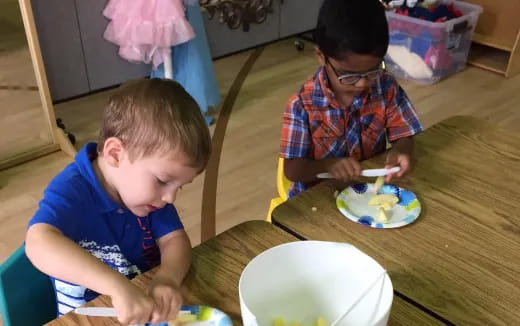 a couple of boys eating at a table