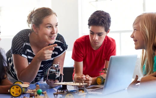 a group of people looking at a laptop